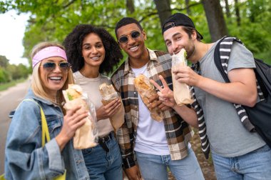 Boş zaman. Gençler sandviç yiyor ve neşeli görünüyorlar.