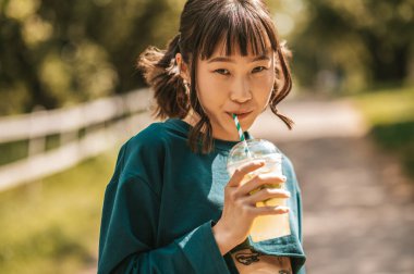 Limonata. Limonata içen tatlı Asyalı kız samanlıkta gelişiyor.