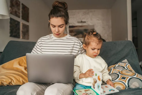 Vrouwelijke Freelancer Werkt Aan Laptop Terwijl Haar Dochter Bladert Door — Stockfoto