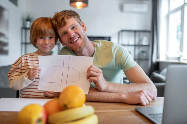 Happy family. Dad and son feeling playful and looking happy