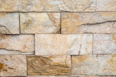 Duvarın arka fonu doğal kayrak taşı grisinden dikdörtgen kiremitlerden yapılmış, bej rengi ve güzel bir taş deseni var. Arkaplan dokusu tasarımı.