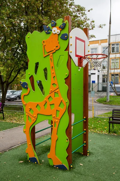 バスケットボールのフープを持つ木製のスウェーデンの壁と緑の木々の背景に明るい緑とオレンジのキリンのパターン 遊び場 スポーツ 健康エンターテイメント — ストック写真