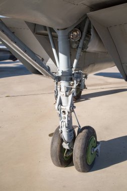 Avcı bombardıman uçağının ön iniş takımları, havaalanının beton sahasının arka planına karşı çelik renklidir. Askeri teçhizat füze helikopterleri.