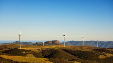 Sardunya 'daki bir dağ rüzgâr çiftliğinde gün batımında rüzgar türbinleri. Yenilenebilir enerji konsepti, yeşil enerji üretimi. Enerji endüstrisi.