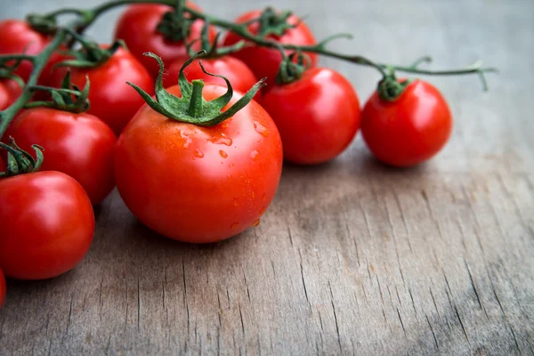 Pomodori rossi freschi deliziosi su un vecchio backgro da tavolo in legno — Foto Stock