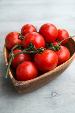 Kalp şekli ahşap plaka üzerinde taze kırmızı lezzetli domates