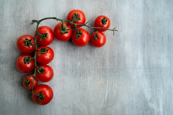 Canto de tomates deliciosos vermelhos frescos em um velho tablet de madeira — Fotografia de Stock