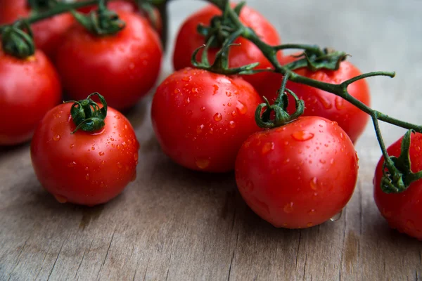 Ferske røde, deilige tomater på en gammel bordplate av tre – stockfoto