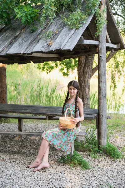 Buena chica sentada en el bosque con cesta — Foto de Stock