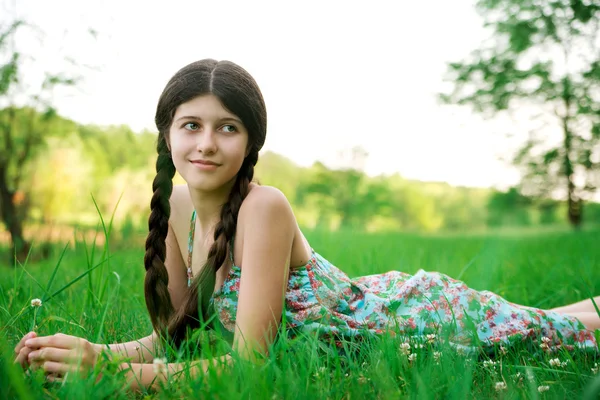 Trevlig tjej med vackra leende poserar på gräset — Stockfoto