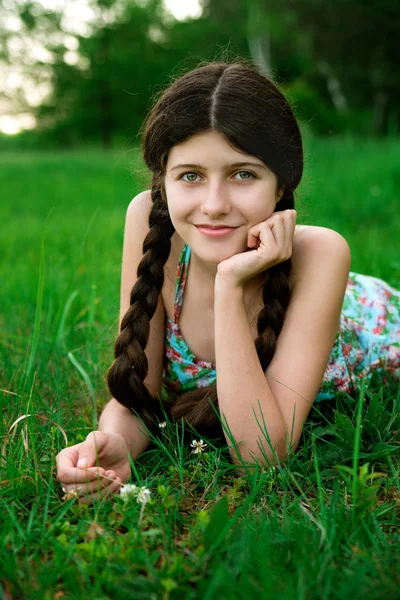 Güzel kız güzel bir gülümseme ile çim üzerinde poz — Stok fotoğraf