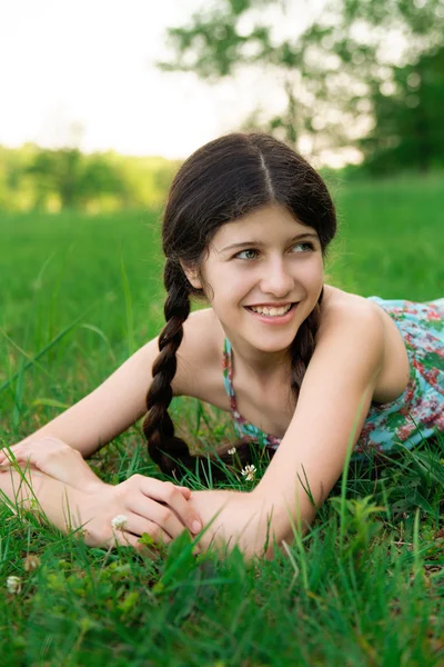 Bella ragazza con un bel sorriso posa sull'erba — Foto Stock