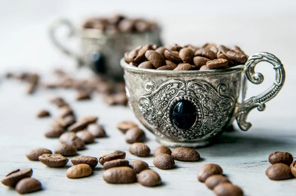 Kaffebönor i silver vintage koppar på trä bakgrund — Stockfoto