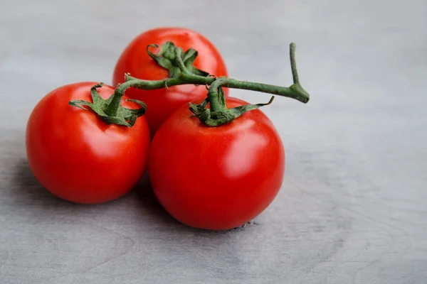 Tomates deliciosos vermelhos frescos em um velho backgrou de mesa de madeira — Fotografia de Stock