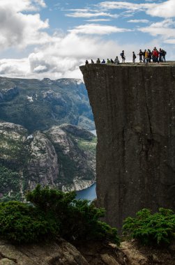 tourists on Preikestolen cliff in Norway, Lysefjord view clipart