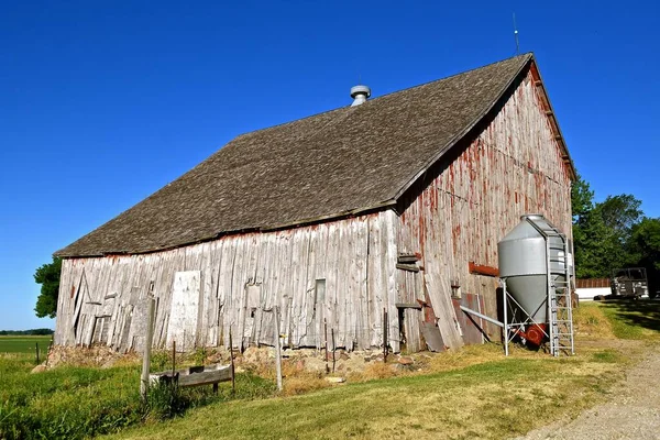 干し草のロフトのある美しい風化した馬小屋は 岩の上に置かれた基盤にあります — ストック写真