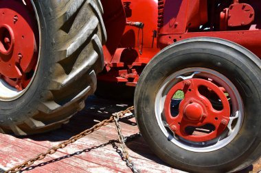 Gel bakalım zincir çekenler, kırmızı bir traktörü römorka bağla.