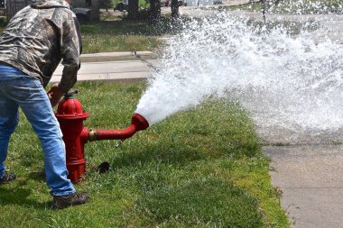 Sifonu çekilen ve test edilen bir yangın musluğu bir su deresi bırakır.