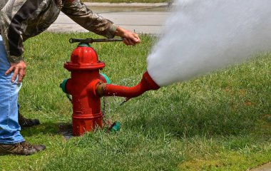 Sifonu çekilen ve test edilen bir yangın musluğu bir su deresi bırakır.