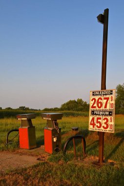Shuttered rural gas pumps next to a corn field in the country