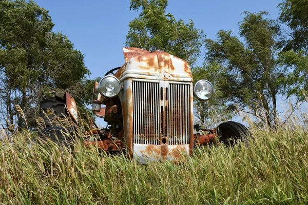 旧的生锈的拖拉机部分地藏在长草中 — 图库照片