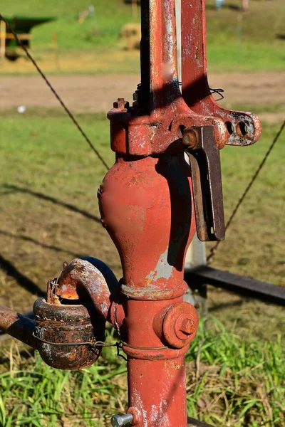古い色あせた赤い手の水ポンプは水の噴出と接続されています — ストック写真