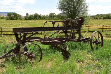 A rusted old road grader which was operated by the hand wheels in the back