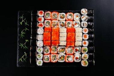 Siyah arka planda Japon suşi ruloları olan farklı bir set.