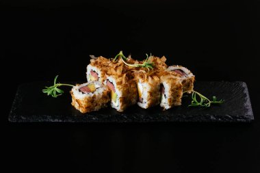 Somonlu suşi ve siyah arka planda sos.