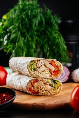 Ahşap arka planda tavuk, sebze ve peynirli ev yapımı shawarma. seçici odak