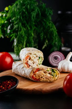 Ahşap arka planda tavuk, sebze ve peynirli ev yapımı shawarma. seçici odak
