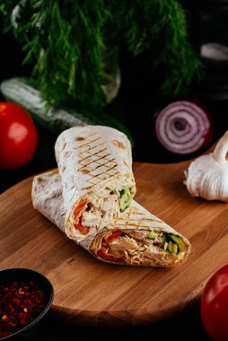 Ahşap arka planda tavuk, sebze ve peynirli ev yapımı shawarma. seçici odak