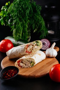 Ahşap arka planda tavuk, sebze ve peynirli ev yapımı shawarma. seçici odak