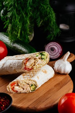 Ahşap arka planda tavuk, sebze ve peynirli ev yapımı shawarma. seçici odak