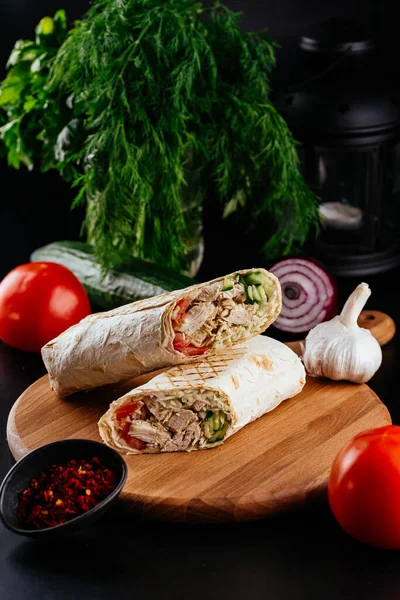 Ahşap arka planda tavuk, sebze ve peynirli ev yapımı shawarma. seçici odak