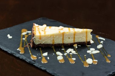 Koyu arkaplanda kremalı ve dutlu lezzetli pasta.