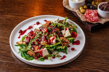 Taze sebzeli salata ve ahşap arka planda peynir.