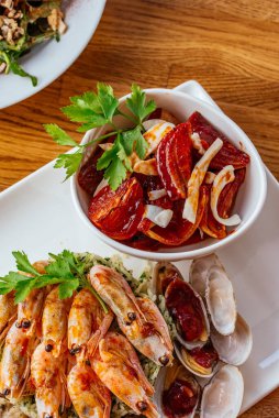 Ahşap tahtada ızgara deniz ürünü ve baharatlı sos..