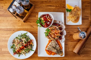 Tahta masada sebze ve sos ile ızgara tavuk kanadı.