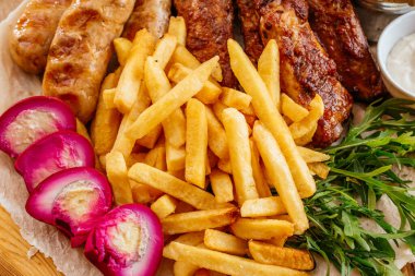 Kızarmış domuz pirzolası, patates kızartması ve sebze. 