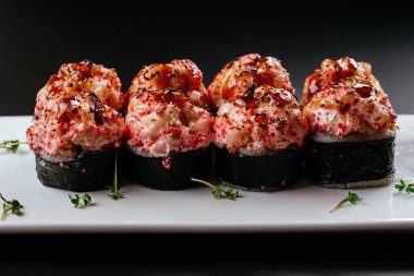 Siyah arka planda yılan balığı ve deniz ürünleri olan suşi.