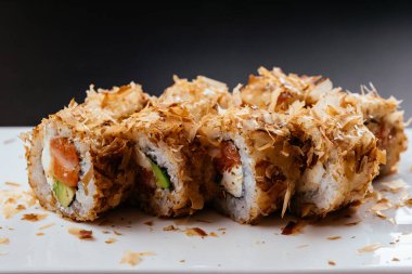 Somon ve avokadoyla kızarmış suşi rulosu.