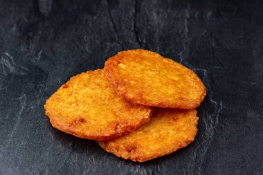 Siyah arka planda kızarmış patates krepleri.