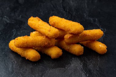 Siyah arka planda kızarmış peynir çubukları