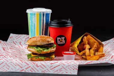 İçkili hamburger ve siyah arka planda patates kızartması, DZ burger.