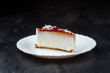 Siyah arkaplanlı kremalı cheesecake.
