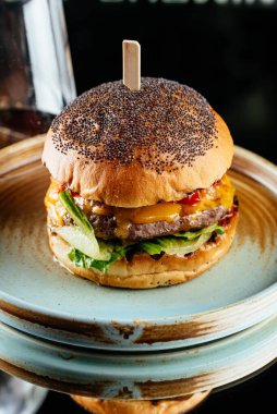 Sebzeli lezzetli hamburger ve ahşap masada peynir.