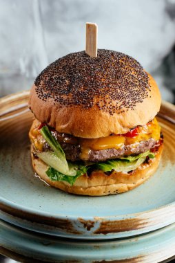 Sebzeli lezzetli hamburger ve ahşap arka planda peynir.