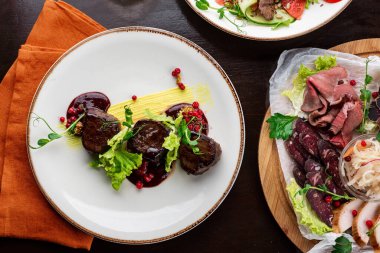 Beyaz tabakta salata ve sebzeli biftek.