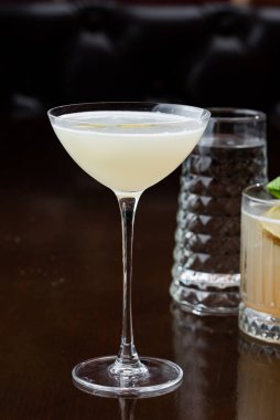 Siyah arka planda buz küpleri olan bir bardak martini.